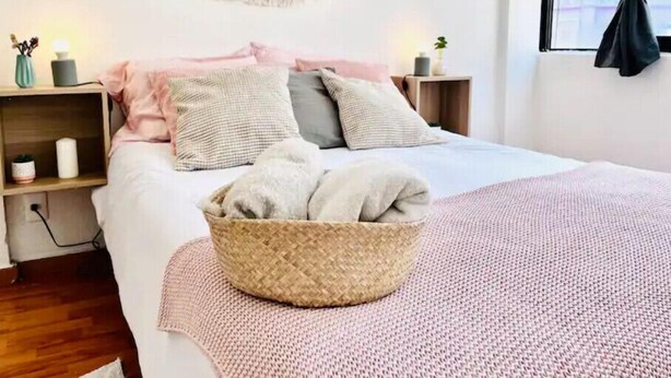 A neatly arranged bedroom with a bed, bedside tables, a wall-mounted macrame, and a window with curtains. - Cozy MEX-style apartment just steps from Reforma. (Ciudad de México)