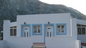 Ein Gebäude mit flachem Dach, einer Treppe, die zum Eingang führt, und einer bergigen Kulisse.
