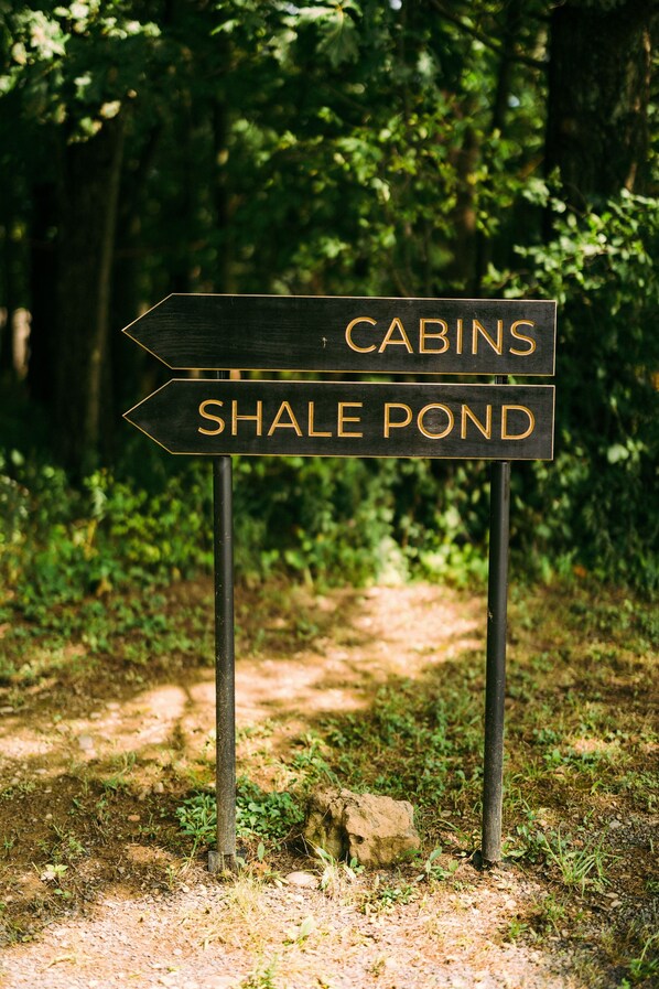A directional signpost with 'Cabins' and 'Shale Pond' written on it.