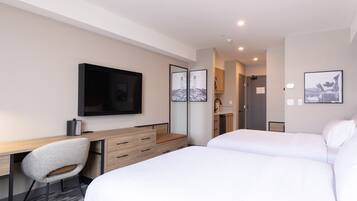 Een moderne hotelkamer met een bed, een bureau, een stoel en een televisie.