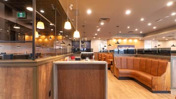A modern restaurant with wooden furniture, pendant lighting, and a central counter.
