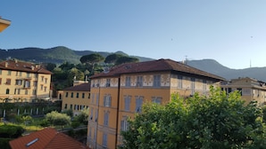 A residential area with multi-story buildings, some with balconies, and a mountainous backdrop. - Casa di Ellen 200 meters from the beach (string:GE)