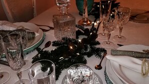 A table set for a formal dinner with crystal glassware, a candelabra, and decorative pine branches. - Casa di Ellen 200 meters from the beach (string:GE)