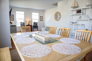 A dining area with a wooden table, white doilies, and a glass-top center. - Centrally located, spacious, fully equipped townhome. Dog Friendly! (North Charleston)