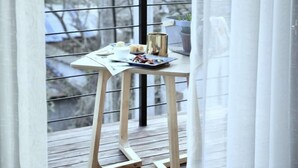 A balcony with a wooden table, a small plant, and a cup. - Wonder Villa (Deqing)