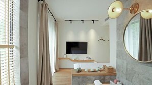 A modern bathroom with a large mirror, a bathtub, and a vanity. - Wonder Villa (Deqing)