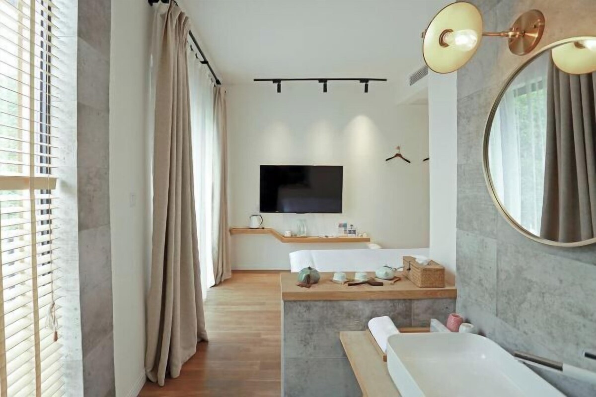 Un baño moderno con un espejo grande, una bañera y un tocador.