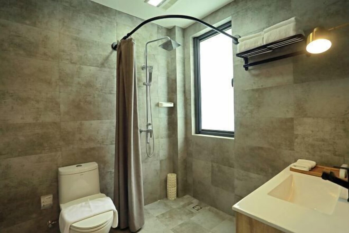 A modern bathroom with a shower, toilet, and sink.