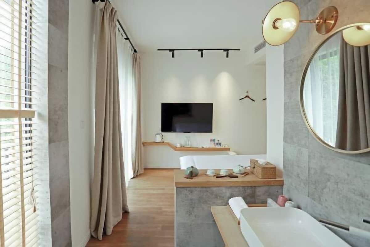 Un baño moderno con bañera, tocador y un espejo grande.