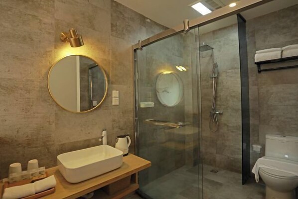 A modern bathroom with a glass-enclosed shower, a round mirror, and a wooden vanity with a large sink. - Wonder Villa (Deqing)