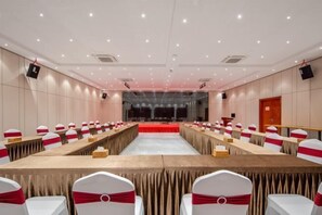 A conference room with a long table, chairs, and a stage. - Qianmen Holiday Inn (Zhuhai City Rail Mingzhu Station) (Zhuhai)
