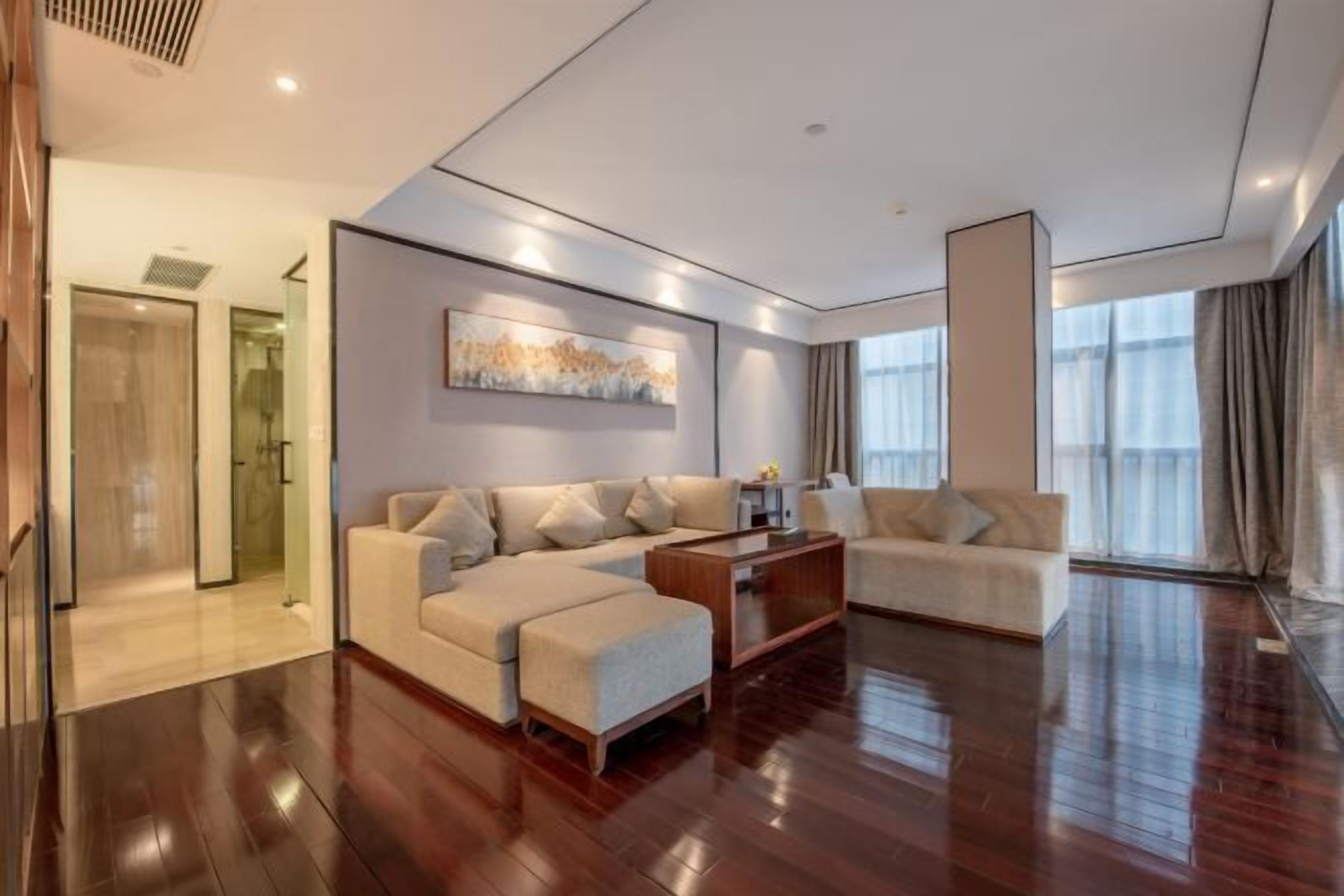 Una sala moderna con un sofá, un reposapiés y una mesa de centro.