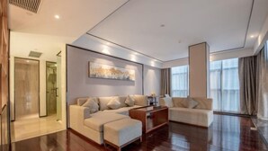 A modern living room with a sofa, ottoman, and a coffee table.