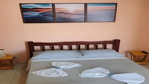 Ein Schlafzimmer mit einem Bett, zwei Nachttischen und einem Wandbild darüber.