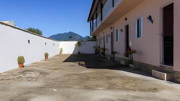 A building with a flat roof, potted plants, and a mountain in the background.