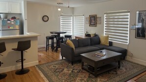 A modern living room with a gray sofa, a coffee table, and a ceiling fan.