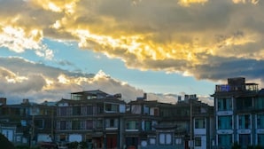 A row of traditional buildings with a clear sky and clouds.