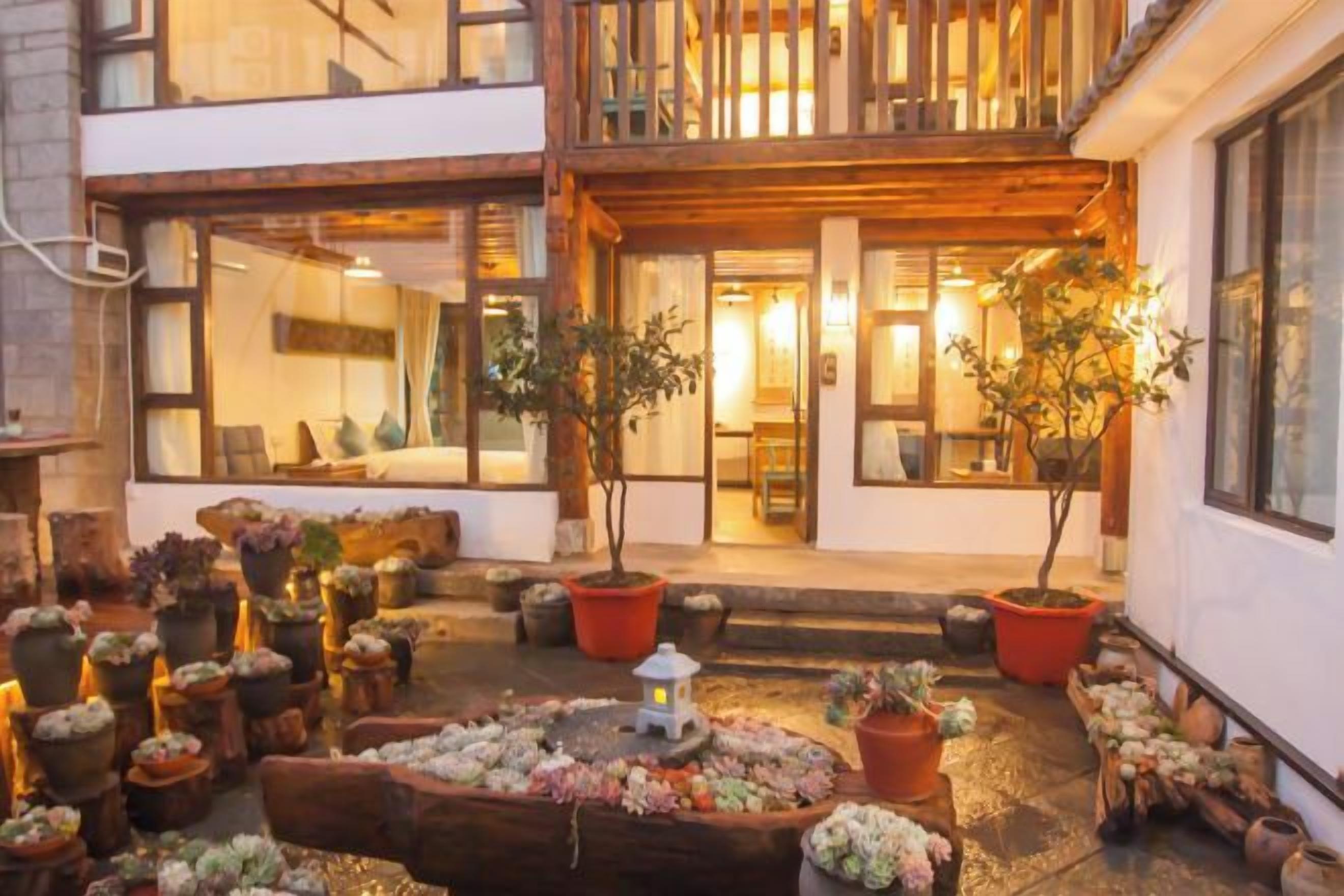 A courtyard with potted plants and a small lantern.