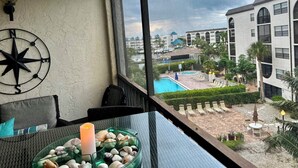 A room with a view of a swimming pool and a building complex. - Beautifully updated one bedroom one bath 4th-floor unit (Marco Island)