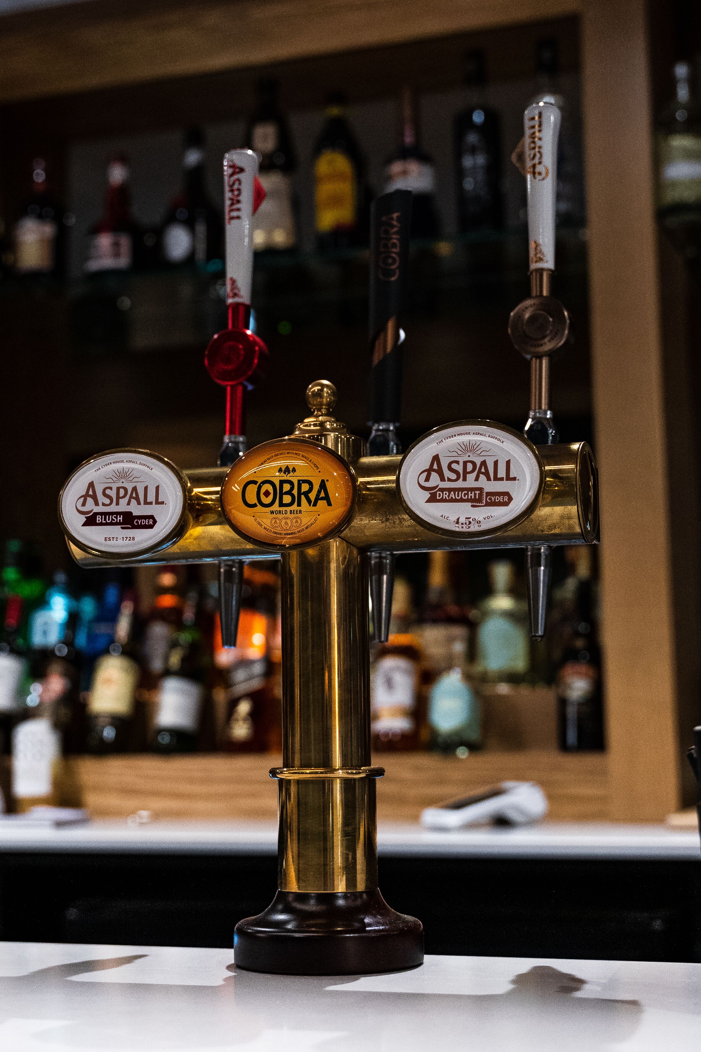 A tap with two spouts labeled "Aspall" and "Cobra" beer taps.