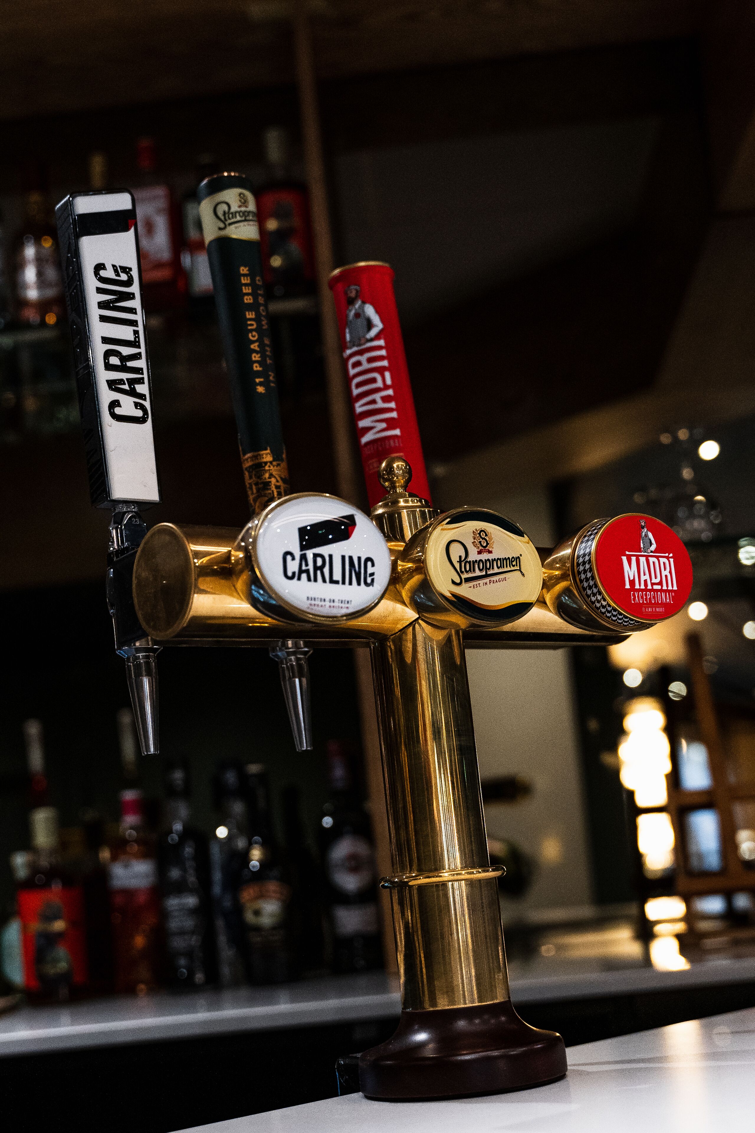Un grifo con tres marcas de cerveza: Carling, Staropramen y Mahou.