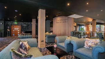 Een moderne zithoek met banken en een bar.