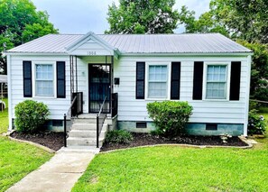 A single-story house with a front porch, a number '1006' on the door, and a well-maintained lawn.