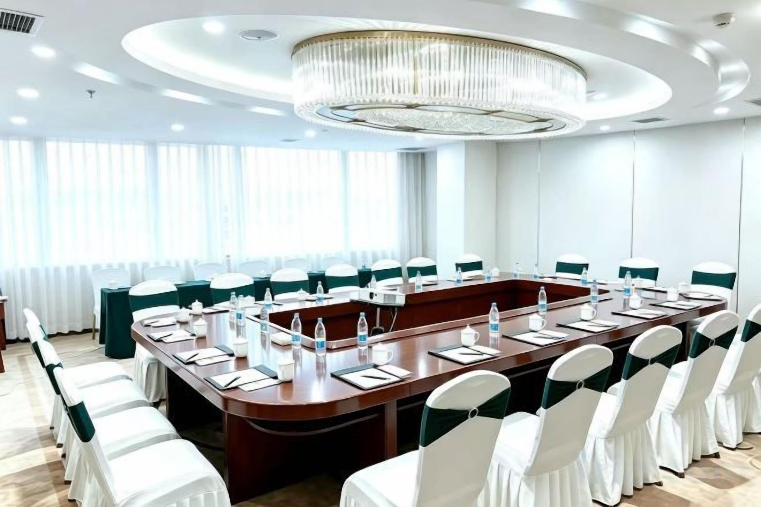 A conference room with a long table, chairs, and a chandelier.