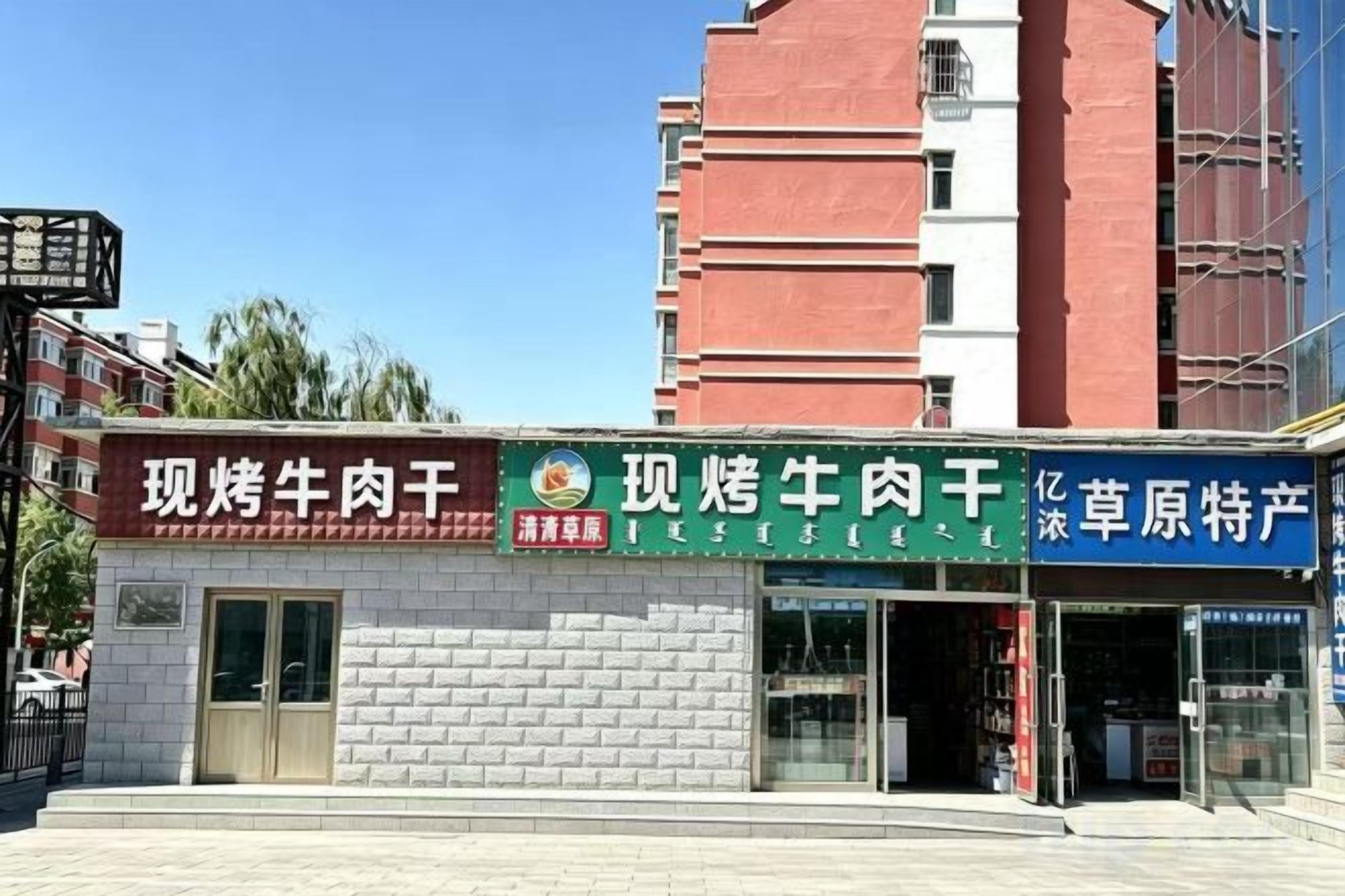 A storefront with multiple signs, including one for '现烤牛肉干' and another for '草原特产'.