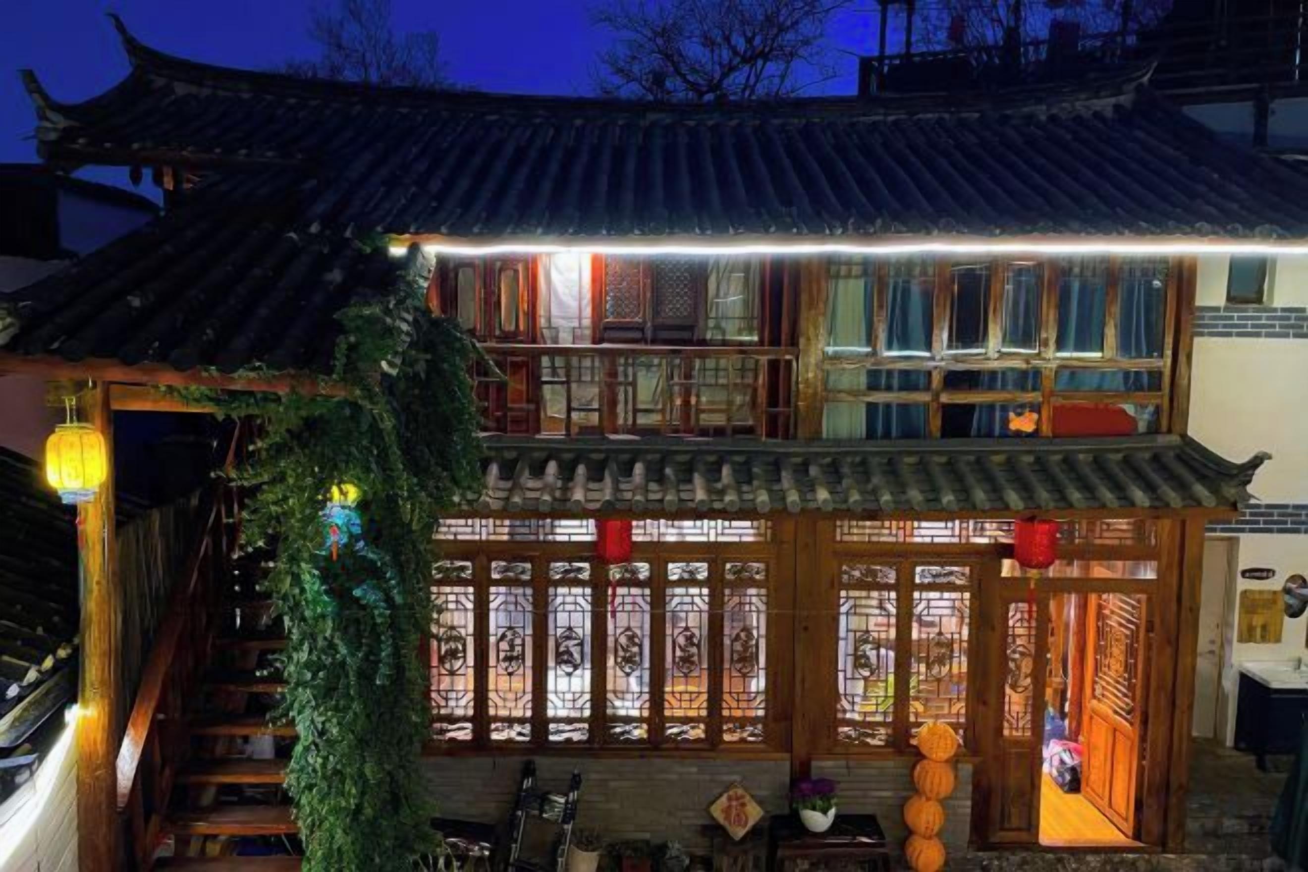 Un edificio tradicional con techo de tejas, puertas de madera y una verja decorativa.