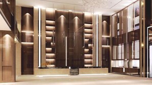 A modern lobby with a central column, wooden paneling, and a patterned glass wall. - Shizhushan dezheng Hotel (Yizheng)
