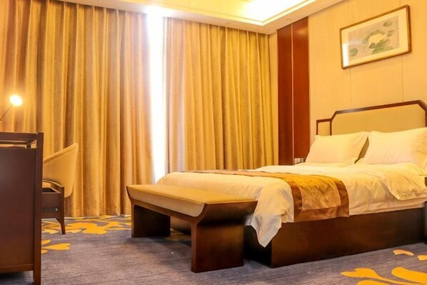 Una habitación de hotel con una cama, un escritorio y una silla.