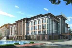 A modern building with a large glass facade, a central courtyard with a fountain, and a well-maintained exterior.