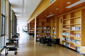 Un interior de biblioteca con estanterías, mesas y sillas.