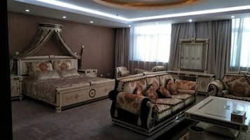 Un dormitorio con cama con dosel, un sofá y una mesita de noche.