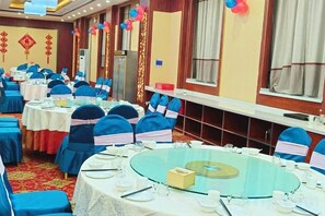A banquet hall with round tables, chairs, and a red carpet. - Xinzhou Conference Hotel (Xinzhou)