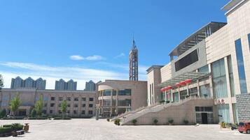 A modern building with a central staircase, large windows, and a flat roof.