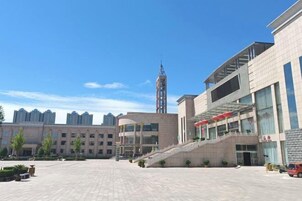 Un edificio moderno con una escalera central, ventanas amplias y un techo plano.