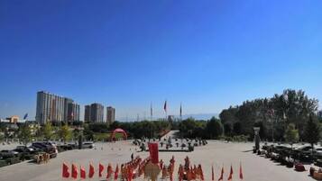 A large open plaza with a clear sky, surrounded by buildings and trees.