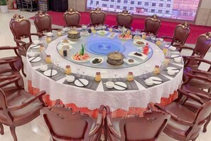 Una mesa redonda con sillas dispuestas para una comida.