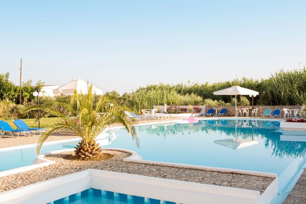 Een seizoensgebonden buitenzwembad en parasols bij het zwembad