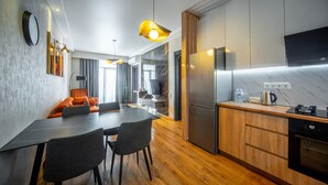 Una cocina moderna con refrigerador integrado, armarios de madera y un comedor con mesa y sillas.
