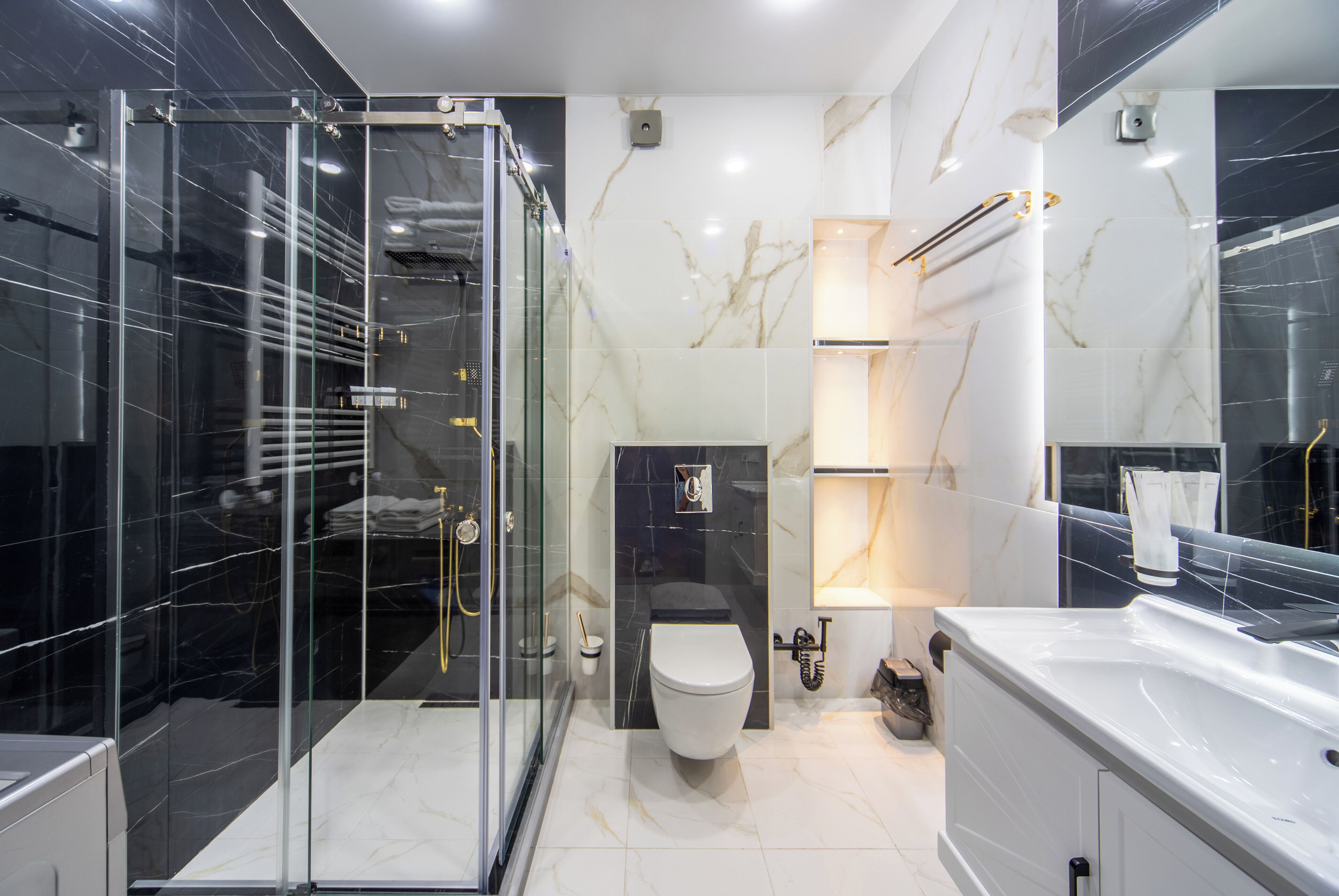 Une salle de bain moderne avec une douche à parois de verre, des toilettes blanches et une grande baignoire.