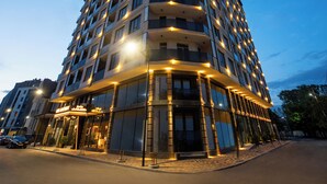 Un hotel de varios pisos con un diseño moderno, con balcones y ventanas amplias.