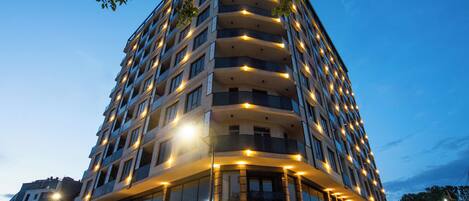 A multi-story hotel with a modern design, featuring balconies and large windows.