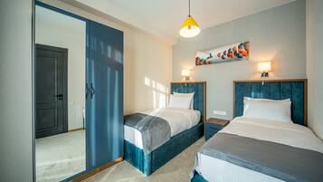 Una camera d'albergo con due letti, un grande specchio e un quadro appeso al muro.
