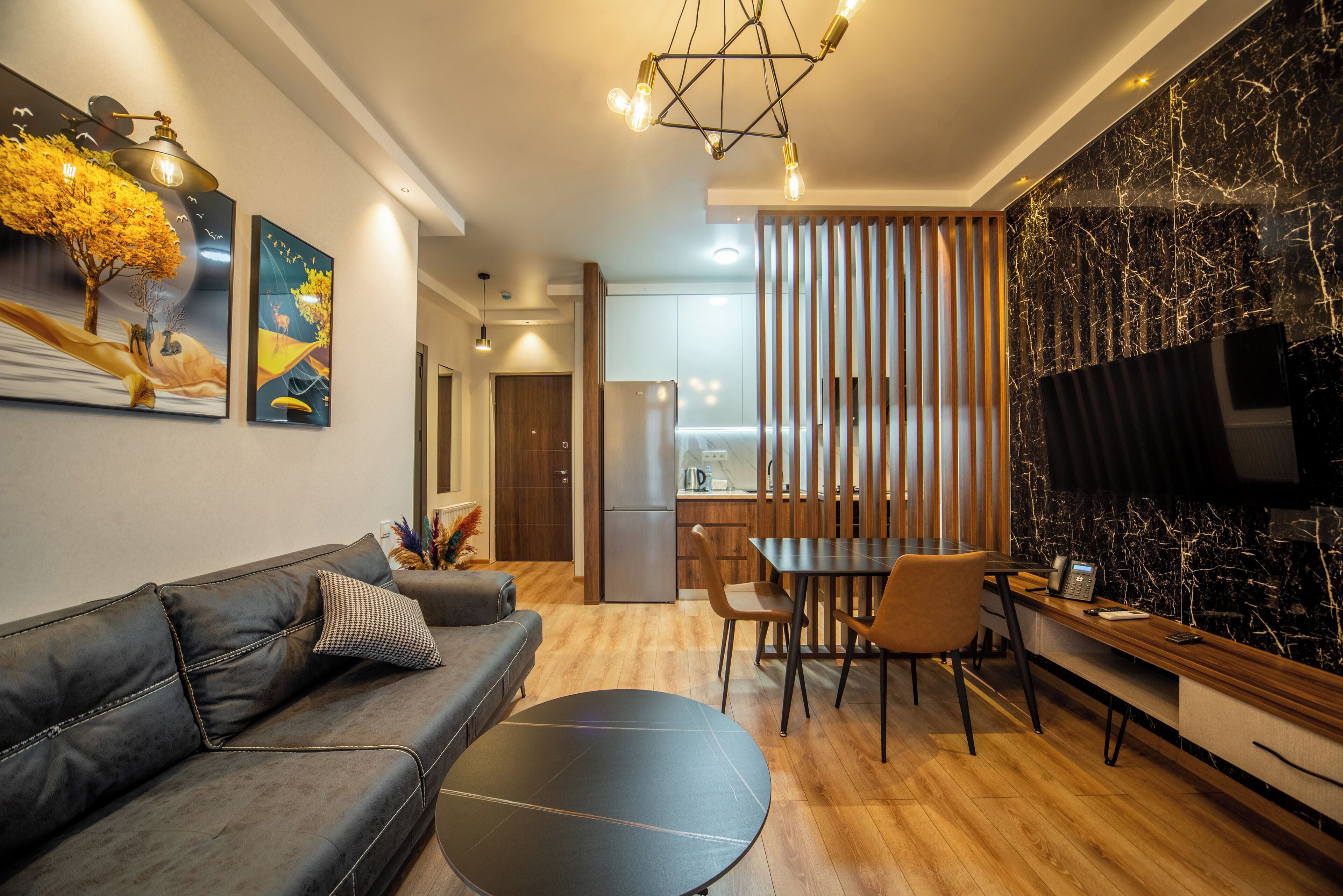 Una sala de estar moderna con un sofá, una mesa de comedor y un televisor.