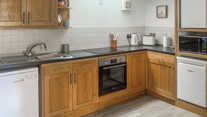 A kitchen with wooden cabinets, a Bosch dishwasher, a Bosch oven, a microwave, and a Siemens toaster.