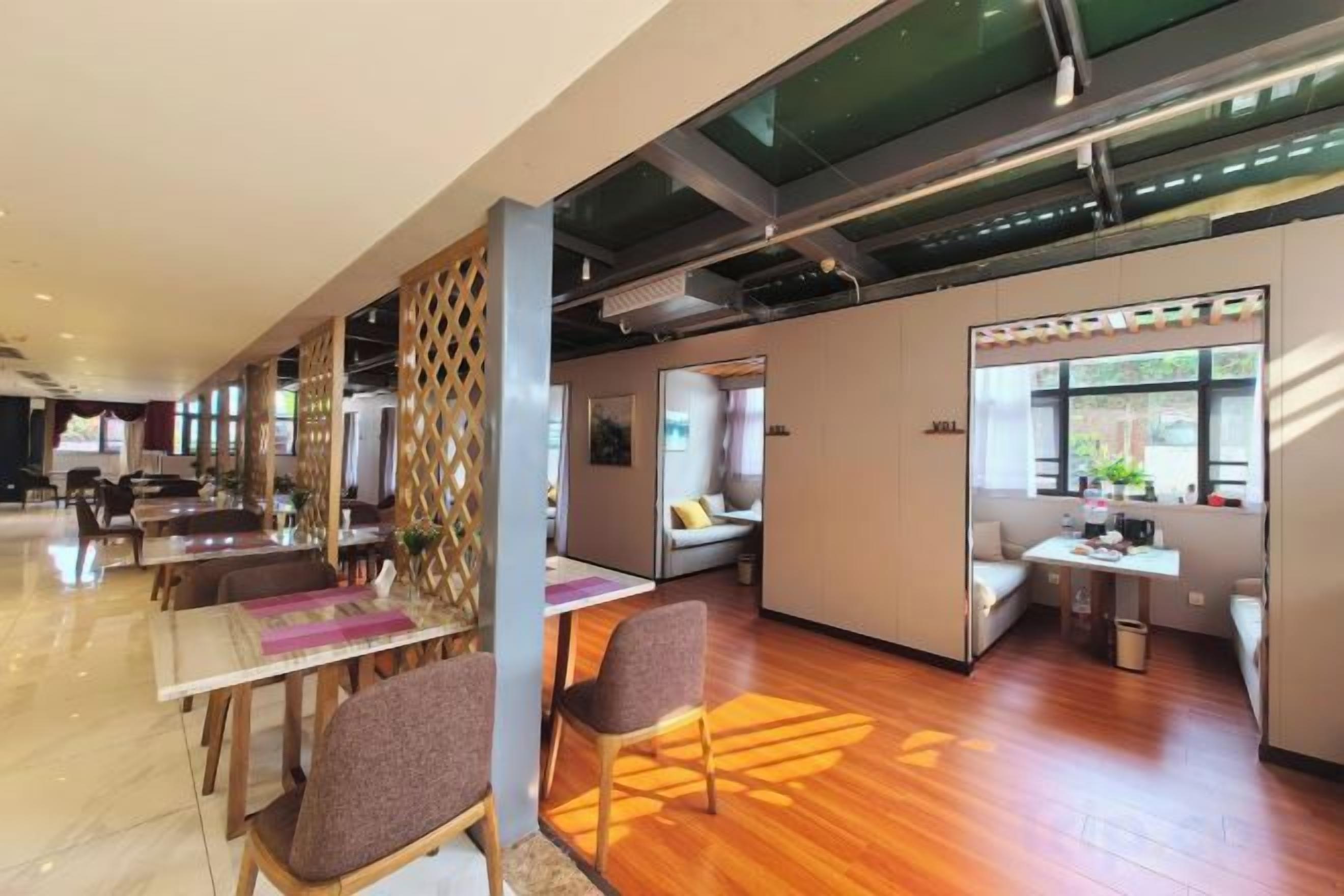 Eine moderne Hotelhalle mit einer langen Rezeption, Sitzbereichen und einer Glastrennwand.