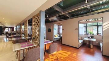 Eine moderne Hotelhalle mit einer langen Rezeption, Sitzbereichen und einer Glastrennwand.